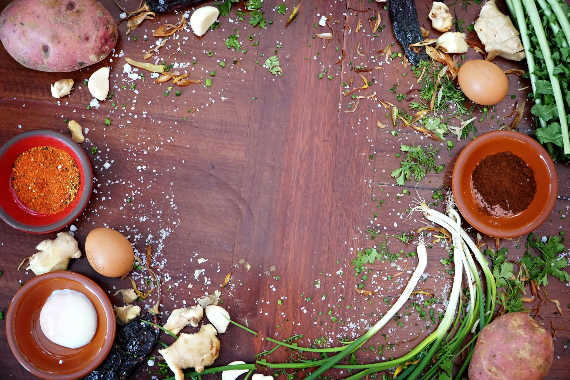 Arrangement of fresh vegetables and spices on a wooden table, ideal for culinary themes.